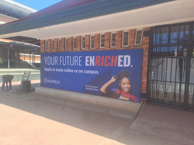 Richfield Your Future Enriched billboard on a brick school building at Bedfordview High School.