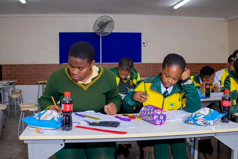 Learners working in notebooks during EduCate at Isizinda.
