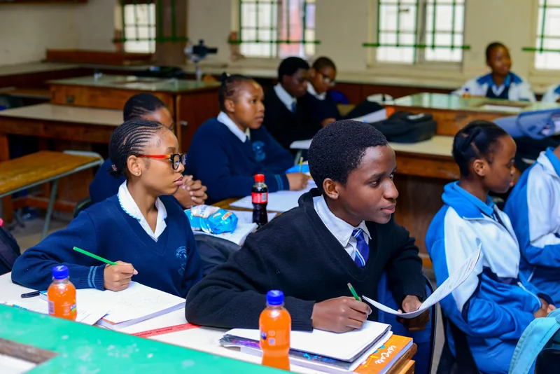Learners holding worksheets and participating in an EduCate classroom session at Ndengetho.