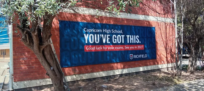 Richfield billboard on the brick wall at Capricorn High School.